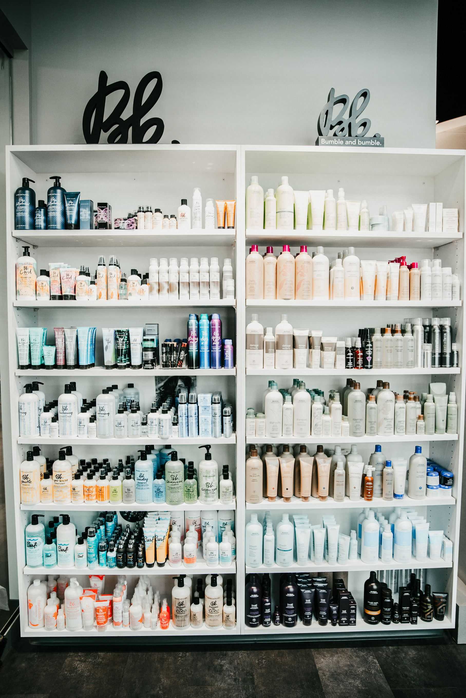 Shelves stocked with various hair care products, including shampoos, conditioners, and styling items.